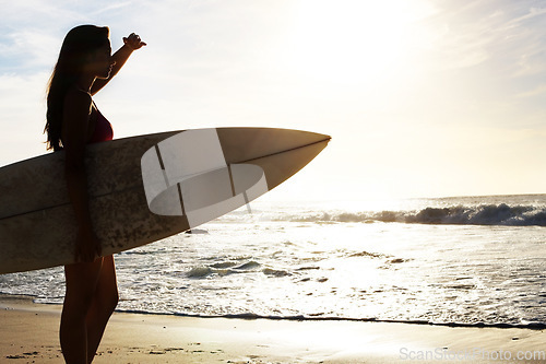 Image of Silhouette, woman surfer on beach with sea and exercise outdoor with surfboard to surf in nature. Sport, shadow and sun with female person looking at ocean waves view with surfing and fitness