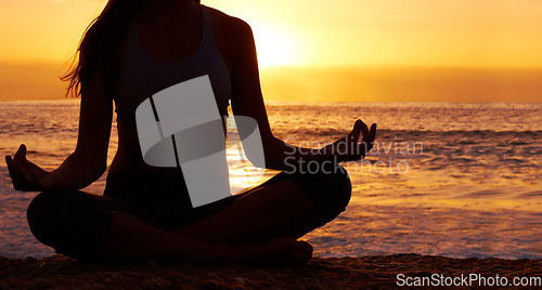 Image of Silhouette, sunset and woman in lotus pose with yoga on the beach, orange sky and meditation outdoor. Healing, wellness and peace in nature with shadow, female yogi back and meditate by the ocean