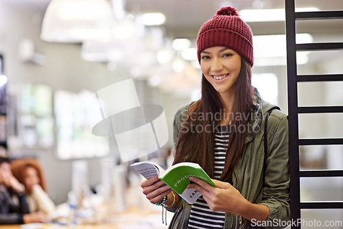 Image of Woman with smile in portrait, student in library reading book and study for exam on university campus. Education, learning and academic development with female person holding textbook for knowledge