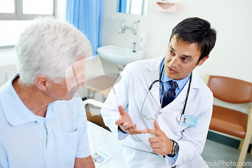 Image of Doctor, senior man patient and talk with information, results and news with consulting health in retirement at clinic. Men, medic and consultation for wellness, healthcare and discussion in hospital