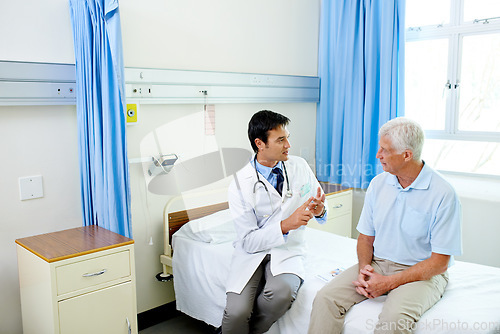 Image of Doctor, senior man patient and speaking with advice, explain or listen to news of health progress in clinic. Men, medic or consultation for wellness, healthcare or discussion in hospital and counting