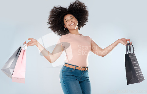 Image of Woman, jump and excited with shopping bag and smile in portrait, retail and happy customer on studio background. Happiness over sale, discount or promotion, female person in air and luxury fashion