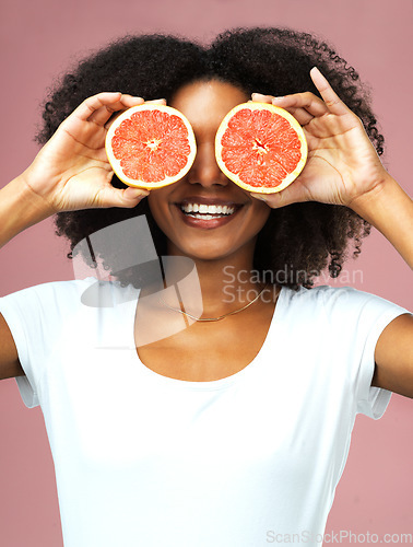 Image of Grapefruit, smile and black woman cover her eyes in studio isolated on a pink background. Natural, fruit and African female model with vegan nutrition, vitamin c or healthy diet, detox or wellness