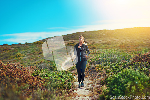 Image of Woman running through field, fitness outdoor with cardio and training for marathon with young athlete and sports. Female runner in nature, hiking trail and run for exercise, healthy and active person