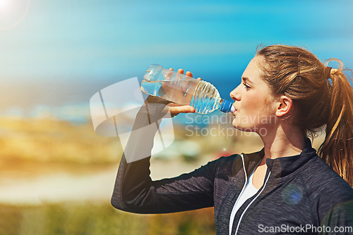 Image of Woman drinking water, health and fitness in nature, blue sky and athlete outdoor with hydration and mockup space. Exercise at beach, female person drink h2o in bottle, workout and break from training