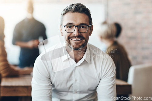 Image of Leadership, portrait of ceo or businessman smile and sitting in office at work with colleagues behind manager. Entrepreneur or business, leader and smiling male person with glasses sit at workplace