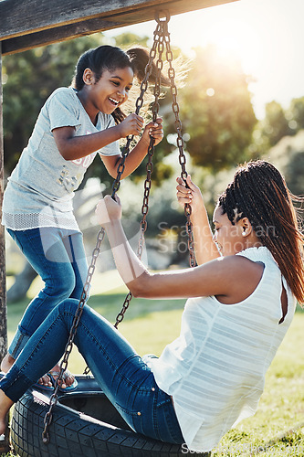 Image of Mother with daughter on swing at park, fun playing together with happiness and carefree outdoor. Love, care and bonding with family in nature, woman and girl enjoying time at playground with freedom