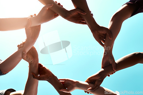 Image of Arms, unity and support with people against a sky background outdoor for motivation, teamwork or unity. Diversity, collaboration and partnership with a group of friends standing in a circle together