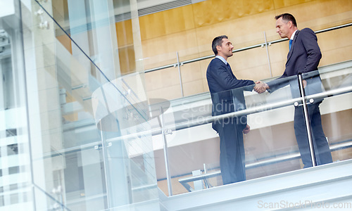 Image of Low angle, business people or handshake in corporate modern office, finance company or investment startup. Men, shaking hands or partnership gesture for workers in welcome greeting or thank you deal