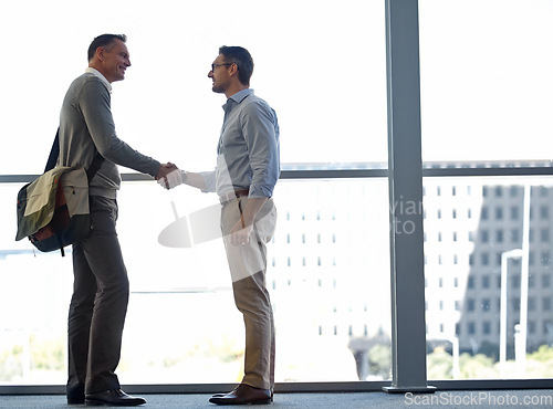 Image of Mature business people, handshake or partnership deal in airport lounge, hotel lobby or modern office for financial crm. Smile, happy or corporate men shaking hands in welcome, thank you or greeting