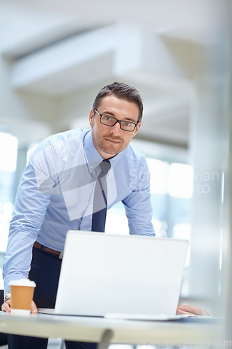 Image of Portrait, laptop and mindset with a business man at work in his office for research or solution. Computer, mission and management of a male employee working on a tech report or planning for success