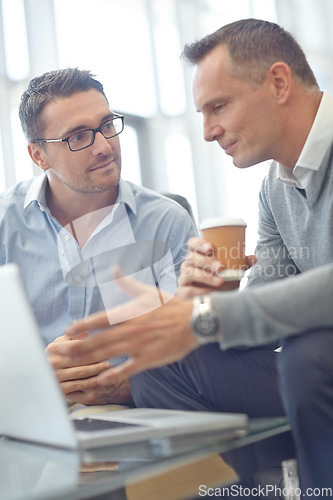 Image of Senior businessman, laptop and colleague in discussion for deal, proposal or idea at office. Business people talking, strategy or planning market strategy or advertising in conversation at workplace