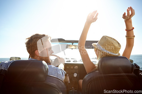 Image of Car, road trip and freedom with a couple by the beach on a drive to enjoy the view during summer together. Travel, transport and driver with a woman sitting hands raised by the ocean with her man