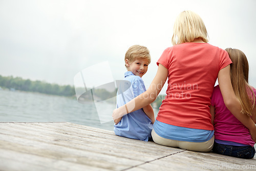 Image of Woman, kids and back for portrait at lake during holiday with water in the outdoor with space. Family, child and mock up with river on the deck for vacation during summer to relax with freedom.