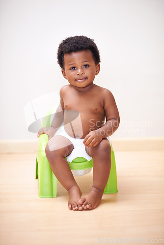 Image of African baby boy, potty training or toilet in home with youth, learning and childhood development on floor. Young toddler, black child or kid sitting in bathroom with diaper, growth and plastic seat