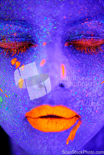 Image of Neon paint, beauty and woman face closeup with dark background and creative cosmetics. Glow, rave makeup and psychedelic cosmetic of a female model with unique and creativity with art in studio