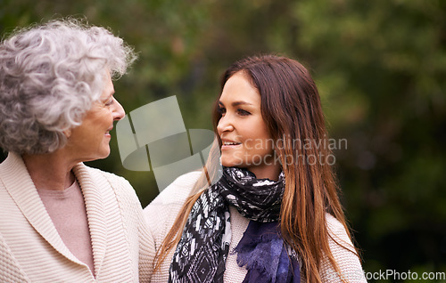 Image of Talking, outdoor and woman with elderly mother together on a nature vacation or holiday bonding in happiness. Retirement, women and young happy female person in conversation and with mom in a garden