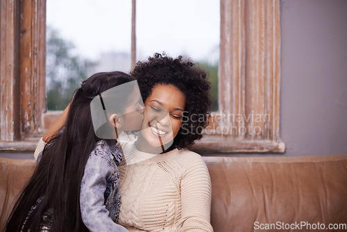 Image of Kiss, mother and girl with a smile, home and loving with joy, relationship and happiness. Family, parents and mama with kid, female child and kissing in the living room, care and bonding on a couch