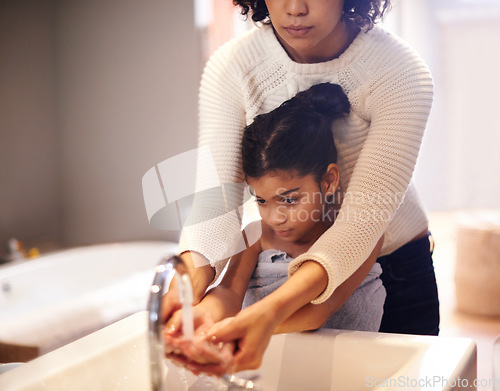 Image of Cleaning, water and washing hands by mother and child in a bathroom for learning, hygiene and care. Basin, wash and hand protection by mom and girl together for prevention of bacteria, dirt and germs