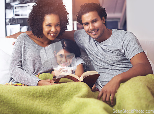 Image of Child, reading book and family portrait in a home for story time on a lounge sofa with mom and dad. A woman, man and girl child together for development, learning and love with a fantasy or fairytale