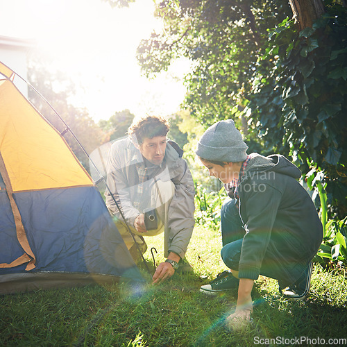 Image of Father, child and hammer tent for camping outdoor in nature on vacation, bonding together and sunset. Dad, boy and preparing camp, learning and helping in forest for travel, holiday and adventure.