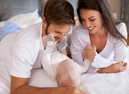 Image of Mom, dad and baby in bedroom for love, care and quality time together. Happy family, parents and newborn child relaxing on bed with smile, childhood development and support to nurture kids at home
