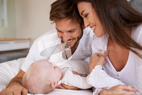 Image of Happy father, mother and baby on bed for love, care and quality time together. Parents, newborn kid and relax in bedroom of family home with smile, childhood development and caring support of bonding
