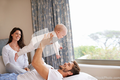 Image of Happy family playing with baby in air, bedroom and fun of love, care and quality time to relax together at home. Mom, dad and holding playful infant kid for happiness, support and newborn development