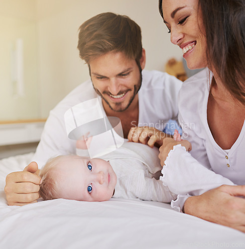 Image of Happy family, baby and parents on bed for love, care and quality time together in house. Mom, dad and cute newborn kid relax in bedroom of home for childhood development, caring support and happiness