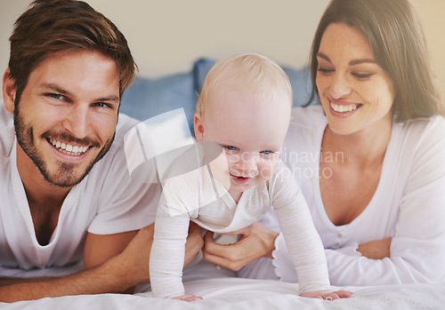 Image of Happy family, baby and parents on bed for love, care and quality time together at home. Mom, dad and cute newborn child relaxing in bedroom for happiness, support and smile for development of kids