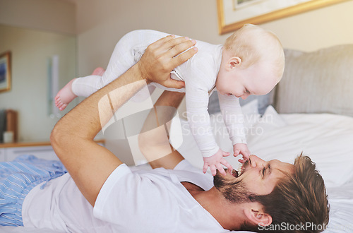 Image of Father, on bed and play with baby girl up in the air or flying daughter and having fun in the bedroom feeling happy. Parent, kid and dad bonding or carefree and excited together in the house