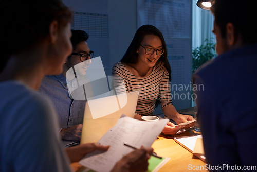 Image of Teamwork, dark and a business group working in the boardroom for planning, strategy or innovation. Meeting, collaboration and overtime with a group of employees at work at night or in the evening