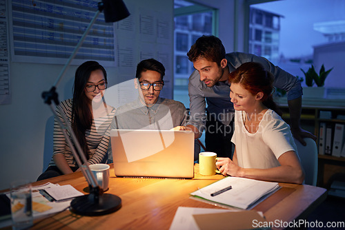 Image of Meeting, night and a business team on a laptop, working in the boardroom for planning, strategy or innovation. Collaboration, teamwork and overtime with a group of employees at work in the evening