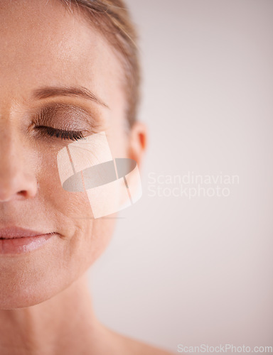 Image of Skin care, mockup and half with a woman face in studio on a gray background for cosmetic beauty advertising. Facial, wellness and eyes closed with a senior female model posing for natural skincare