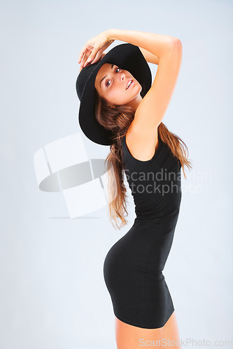 Image of Portrait, profile and woman in studio for fashion, hat and black dress or stylish outfit against blue background. Face, classic and fashionable female model posing, trendy and cool while isolated