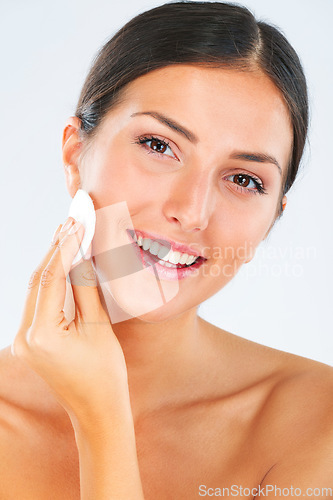 Image of Portrait of a woman with a cotton pad for skincare in studio for a beauty, natural and face routine. Health, wellness and happy female model with cosmetic facial product isolated by white background.