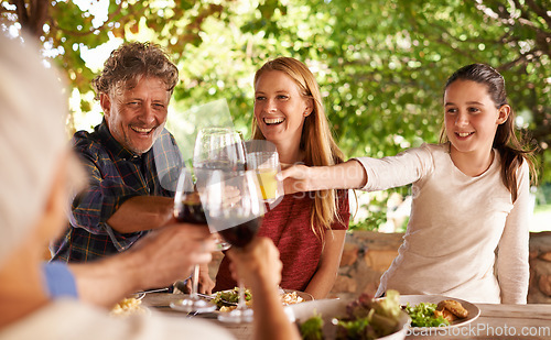 Image of Family, group and wine glass for toast at table for celebration, food or friends at lunch event. Men, women or smile together to celebrate with alcohol, glasses or solidarity at party, dinner or home