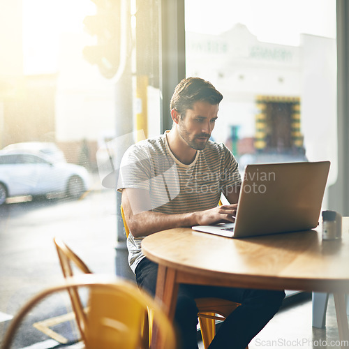 Image of Coffee shop, typing and serious man with laptop and lens flare doing code work in a cafe. Tech, email and male freelancer customer at restaurant with online job and computer writing with focus