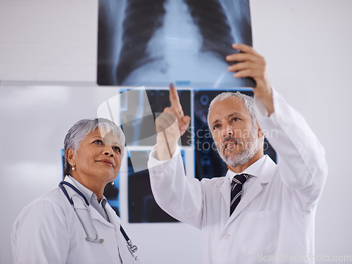 Image of Senior team of doctors, check xray for surgery with people in radiology and cardiovascular health at clinic. Lung scan, old man and woman surgeon collaboration with assessment and problem solving