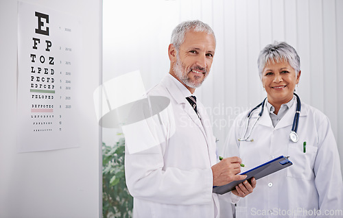 Image of Team of doctors with clipboard, smile and optometrist with medical paperwork, collaboration and health insurance. Senior man, woman in portrait at optometry practice with information and checklist