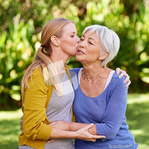 Image of Adult daughter kiss mother, hug and trust with peace outdoor, family spending quality time in garden together. Women embrace while they relax in park, love and care with bonding and affection