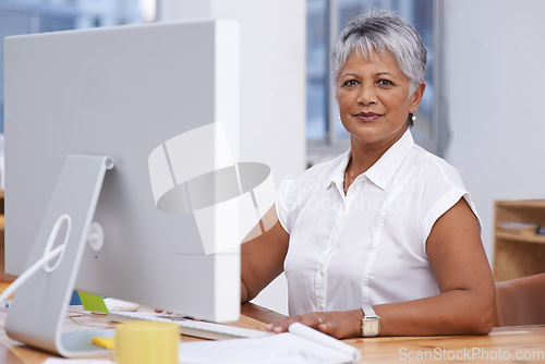 Image of Computer, portrait and mature woman in office for online management, digital planning and working with career mindset. Confident indian person, professional worker or business employee on desktop pc