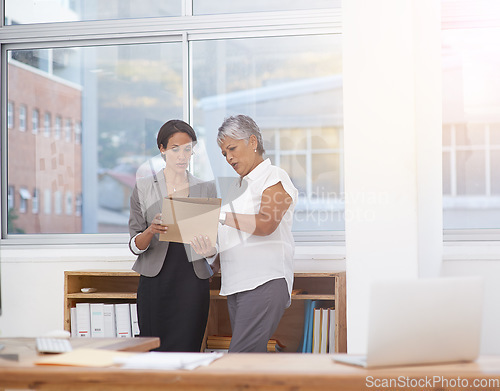 Image of Paperwork, discussion and business women in office for planning, brainstorming or advice. Corporate team or manager and employee together for collaboration, talking or teamwork on a report or project