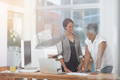 Image of Business women, desk and discussion in office for planning, proposal or advice. Corporate team or manager and employee together for collaboration or teamwork while talking about paperwork or report