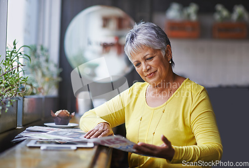 Image of Cafe, newspaper and senior woman reading daily news, article story or morning paper in store. Coffee shop customer, headline information and relax elderly person, female client or lady in restaurant