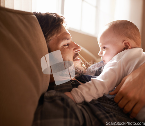 Image of Smile, father and bonding with baby on sofa in home living room or playing together. Happiness, care and dad cuddle with infant, newborn or child on couch in lounge, having fun or enjoying relax time