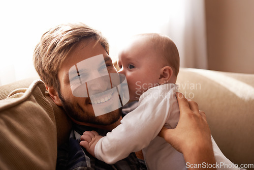 Image of Smile, father and face with baby on sofa in home living room, playing or bonding together. Kiss, care and dad with infant, newborn or child on couch in lounge, having fun or enjoying quality time