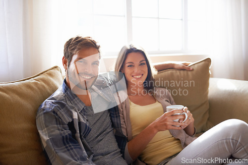 Image of Portrait, coffee and couple relax or smile on a couch together or bonding in the living room and with tea. Man, woman and love or affection with hot beverages or on a break and happy partners at home