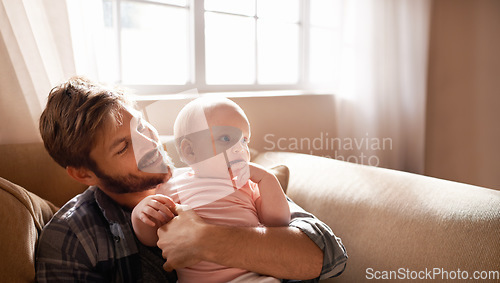 Image of Smile, father and hug baby on sofa in home living room, playing or bonding together. Happiness, care and dad embrace infant, newborn or child on couch in lounge, having fun and enjoying quality time.