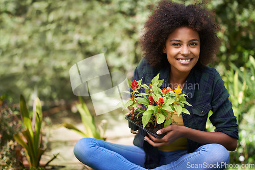 Image of Black woman in garden, smile in portrait with gardening and plant or flower, botany and young gardener outdoor. Happy female person with growth, environment and plants out in nature with landscaping